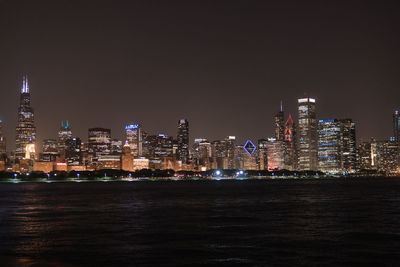 Illuminated buildings in city against sky at night