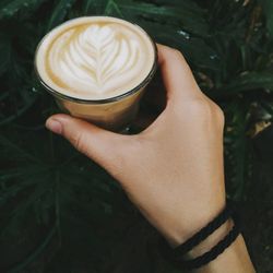 Close-up of hand holding coffee cup