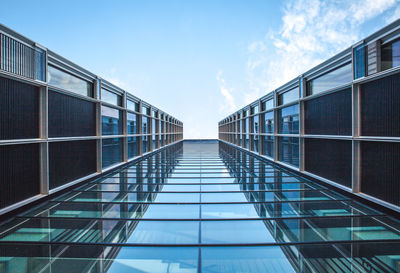 Low angle view of glass building against sky