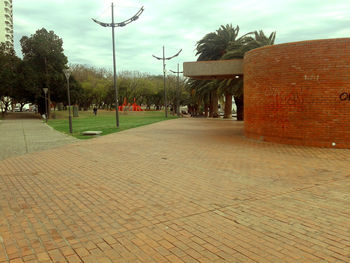 Footpath leading to built structure against sky