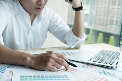 Low angle view of man using laptop on table