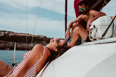 Midsection of woman relaxing on boat sailing in sea