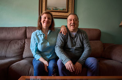 Middle-aged couple poses and smiles for a photo at home