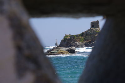 Rock formations by sea against sky