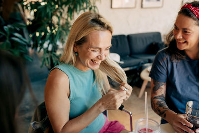 Cheerful happy laughing women sitting in a cafe at a meeting communicate and celebrate.