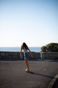 Full length of woman against sea against clear sky