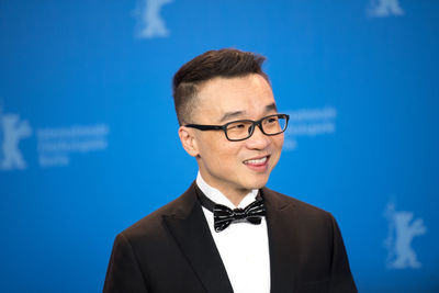 Close-up of man wearing eyeglasses against blue sky