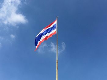 Low angle view of thai flag against blue sky