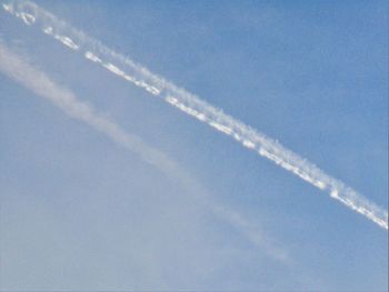 Low angle view of airplane flying against blue sky