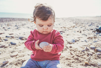 Cute boy holding sand at beach