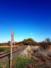 Electricity pylon by trees against blue sky