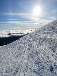 Sun shining through clouds over mountain