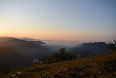 Scenic view of mountains against clear sky during sunset