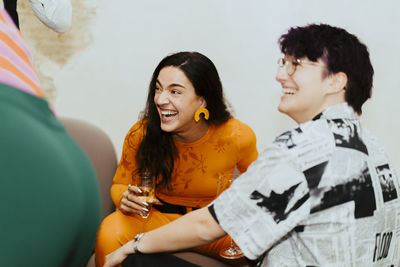 Happy business colleagues laughing while sitting together during event at convention center