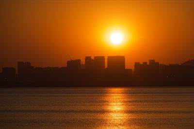 Silhouette buildings against sky during sunset