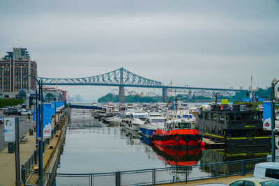 Boats moored at harbor against sky