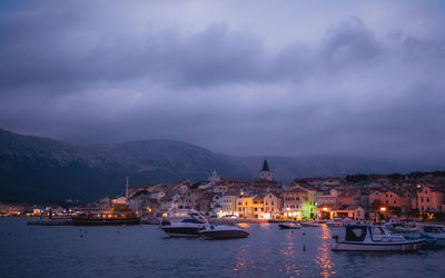 Boats in sea against cloudy sky