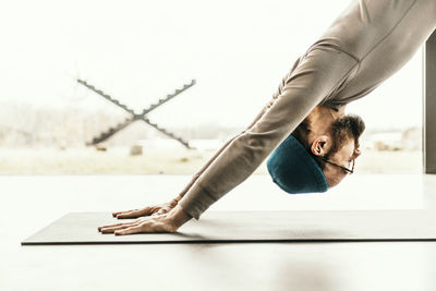 Side view of young man climbing on table