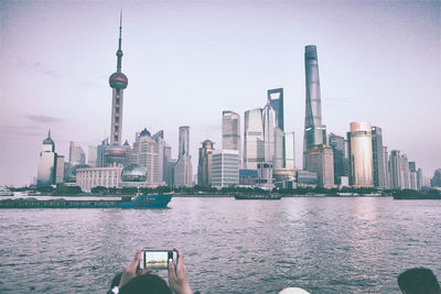 City by river against sky