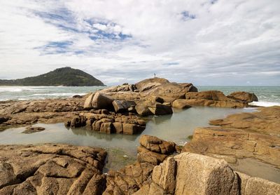 Rock formations on beach against sky