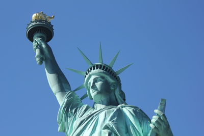 Low angle view of statue of liberty against clear sky