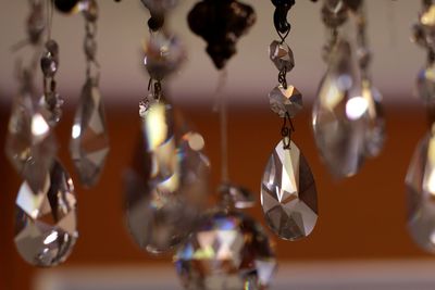 Close-up of chandelier hanging at orange background 