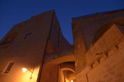 Low angle view of illuminated building against clear blue sky