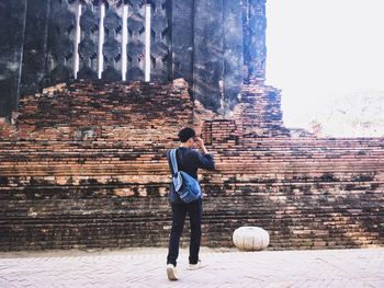 Rear view of man standing against wall