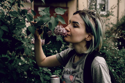 Portrait of beautiful young woman holding flowering plant