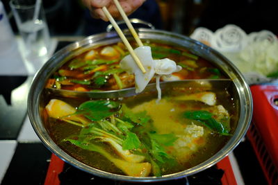 Close-up of hand holding soup in bowl