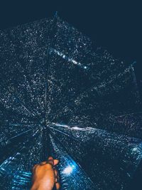 Low angle view of hand on illuminated snow at night