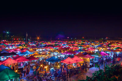 High angle view of illuminated city against sky at night