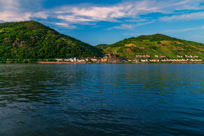 Scenic view of sea by mountains against sky