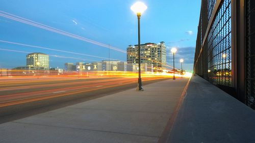 Light trails on road against sky during sunset