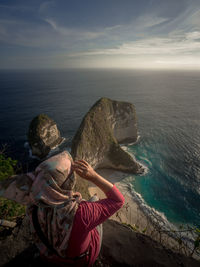 A moslem traveler when sitting down on the top view of kelingking beach bali indonesia on september