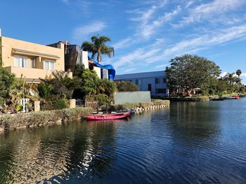 Houses by trees against blue sky