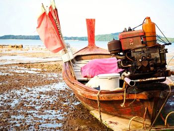 Abandoned ship moored on beach against sky