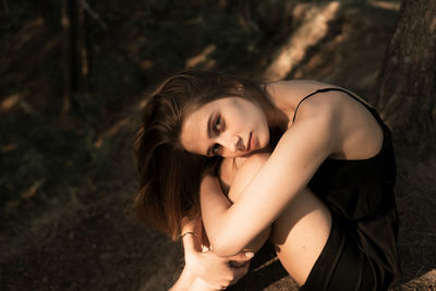 Portrait of young woman sitting on land