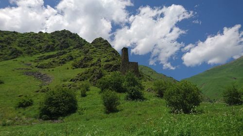 Panoramic view of green landscape and mountains against sky