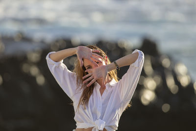 Rear view of woman with arms raised