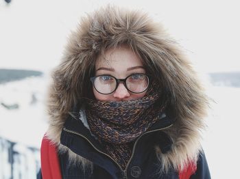 Portrait of young woman in warm clothing standing outdoors