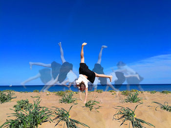 People on beach against clear blue sky