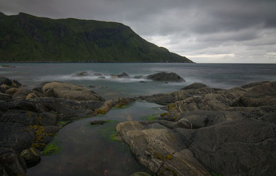 Scenic view of sea and mountains against sky