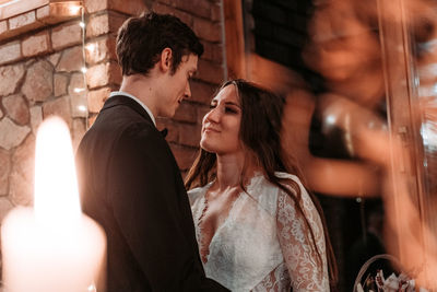 Newlywed couple looking at each other while standing outdoors