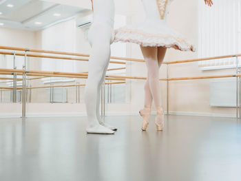 Low section of ballet dancers dancing on floor
