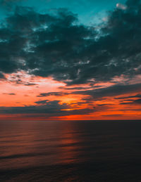 Scenic view of sea against dramatic sky during sunset