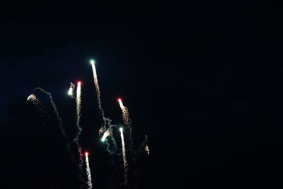 Low angle view of fireworks against sky at night