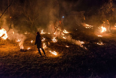 People standing by bonfire