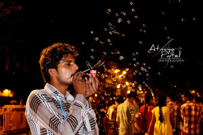 Young man using mobile phone at night