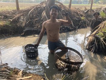 Man and his mother catching fish in the ditch